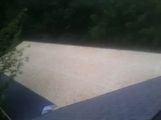 New OSB roof sheathing installed beside an existing shingle roof in Henry